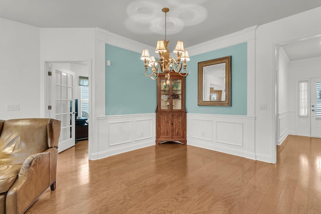 dining room featuring hardwood / wood-style flooring, crown molding, and a chandelier