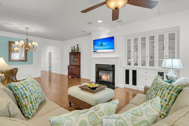 living room featuring wood-type flooring and ceiling fan with notable chandelier