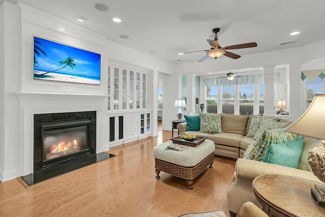 living room featuring hardwood / wood-style floors and ornate columns