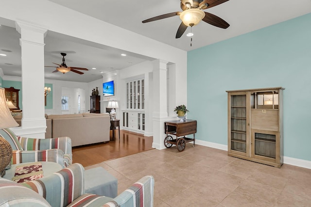 tiled living room with decorative columns and ceiling fan