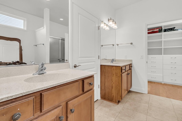 bathroom featuring tile patterned flooring, vanity, and walk in shower