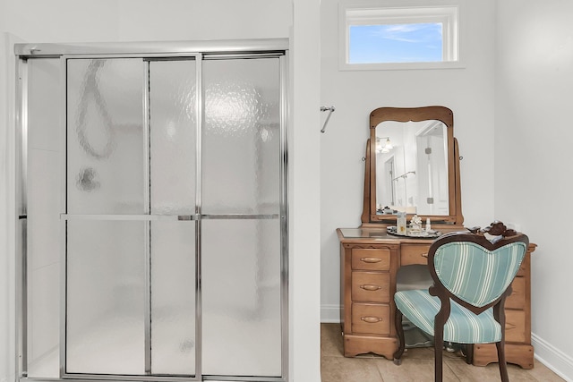 bathroom with an enclosed shower and tile patterned floors