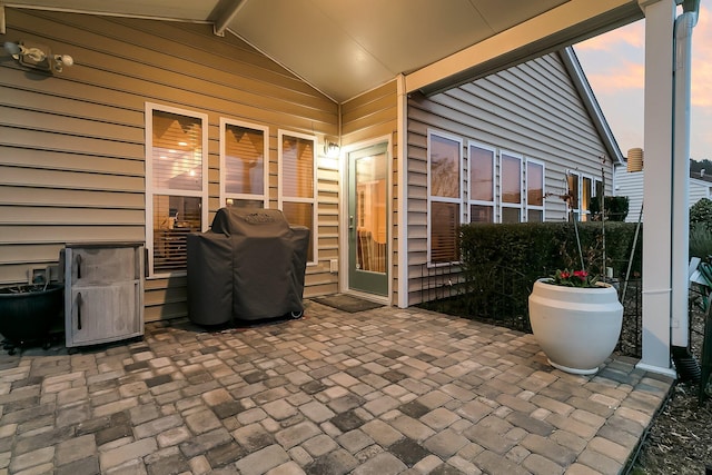 patio terrace at dusk featuring grilling area