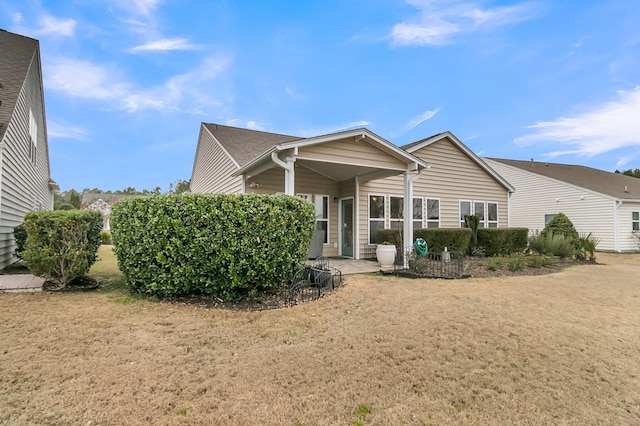 rear view of property featuring a lawn