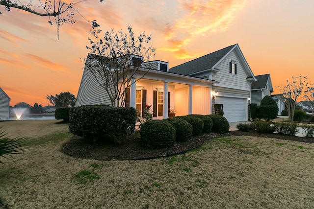 property exterior at dusk with a garage and a yard