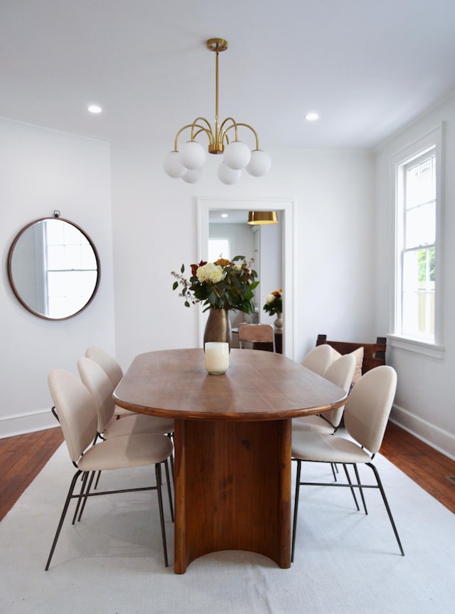 dining space with wood finished floors, recessed lighting, and a chandelier