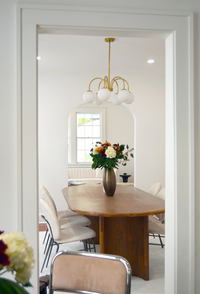 dining area with arched walkways and a notable chandelier