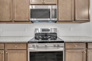 kitchen featuring light stone counters and appliances with stainless steel finishes