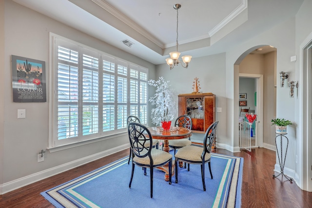 dining area with arched walkways, crown molding, wood finished floors, and an inviting chandelier