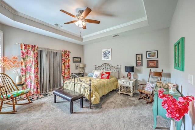 carpeted bedroom with a ceiling fan, ornamental molding, visible vents, and a raised ceiling