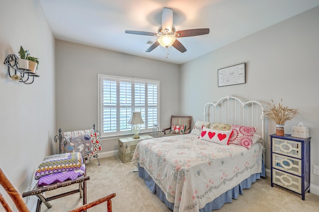 bedroom featuring visible vents, a ceiling fan, baseboards, and light carpet