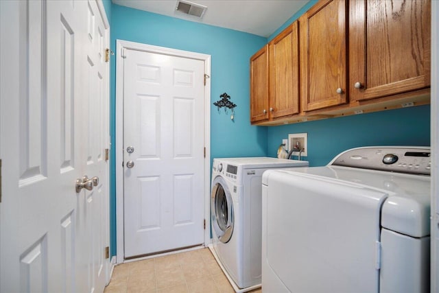 laundry room with cabinets and washer and dryer