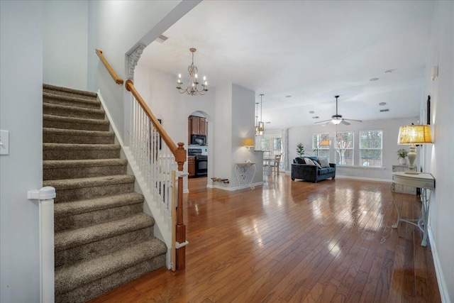 entrance foyer with wood-type flooring and ceiling fan with notable chandelier