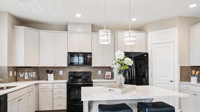 kitchen with white cabinetry, a breakfast bar area, decorative backsplash, hanging light fixtures, and black appliances