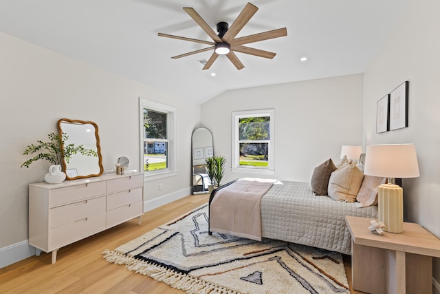 bedroom featuring light hardwood / wood-style floors, vaulted ceiling, and ceiling fan