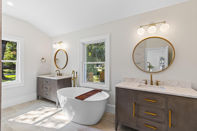 bathroom with tile patterned flooring, a healthy amount of sunlight, and lofted ceiling