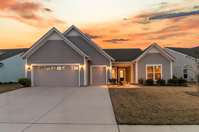 view of front of house featuring a garage and a lawn