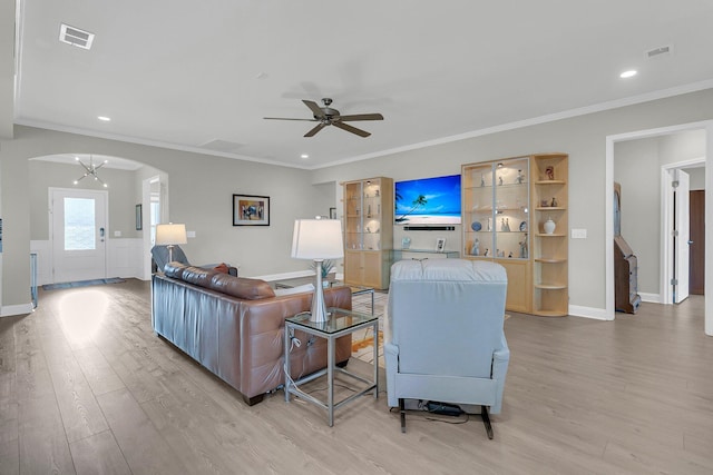 living room featuring ceiling fan, ornamental molding, and light hardwood / wood-style floors