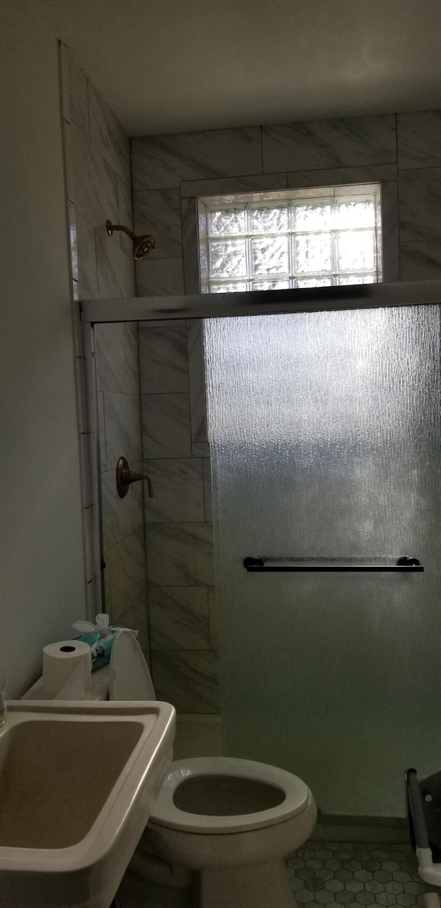 bathroom with tile patterned floors, toilet, an enclosed shower, and sink