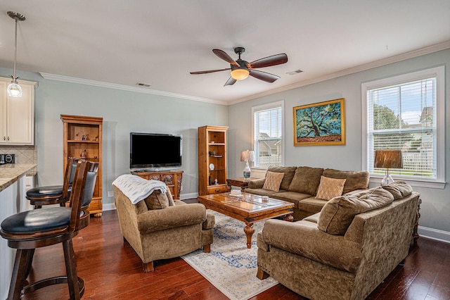 living room featuring plenty of natural light, ceiling fan, dark hardwood / wood-style flooring, and ornamental molding