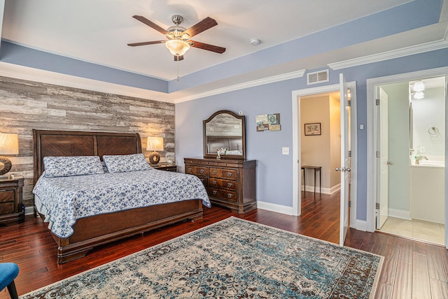 bedroom with wood walls, crown molding, ceiling fan, dark hardwood / wood-style floors, and connected bathroom