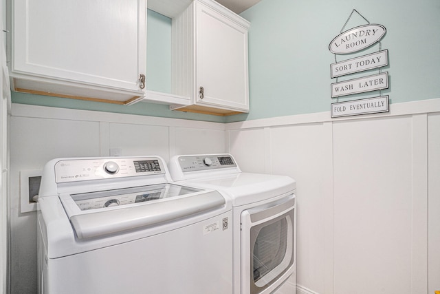 washroom with washer and clothes dryer and cabinets