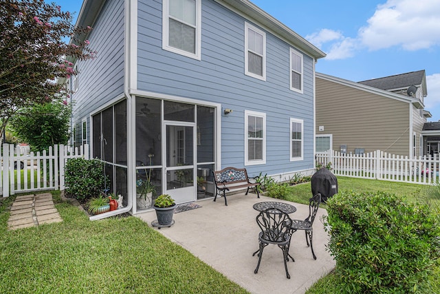 rear view of property with a yard, a patio, and a sunroom