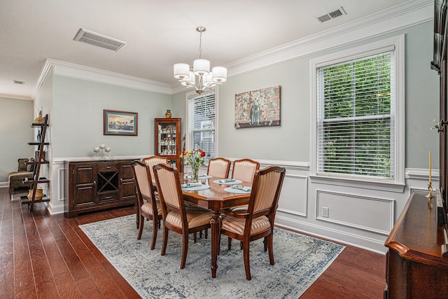 dining room with a notable chandelier, plenty of natural light, ornamental molding, and dark wood-type flooring