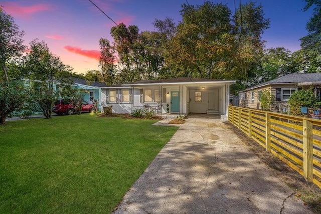 view of front facade featuring a lawn and a carport