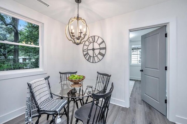 dining area with hardwood / wood-style floors and a chandelier