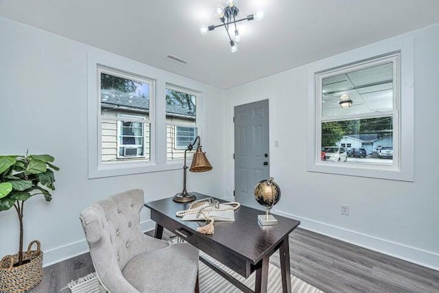 office space featuring dark wood-type flooring and a notable chandelier