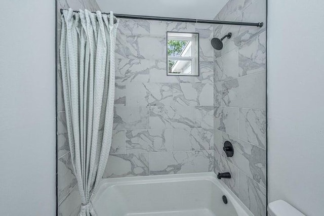 bathroom with shower / bath combo with shower curtain and toilet