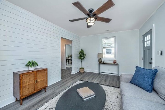 living room with ceiling fan, wood-type flooring, and crown molding