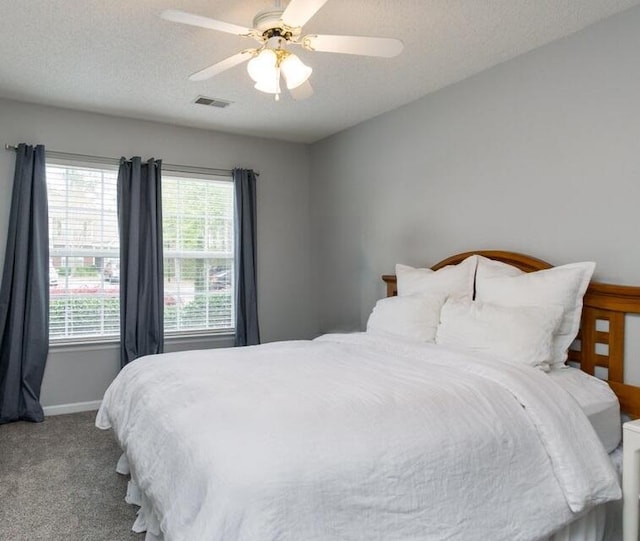 bedroom featuring carpet flooring, ceiling fan, and a textured ceiling