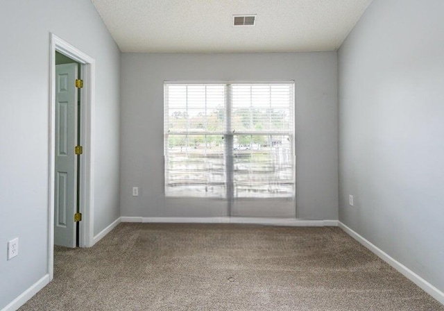 empty room with carpet and a textured ceiling