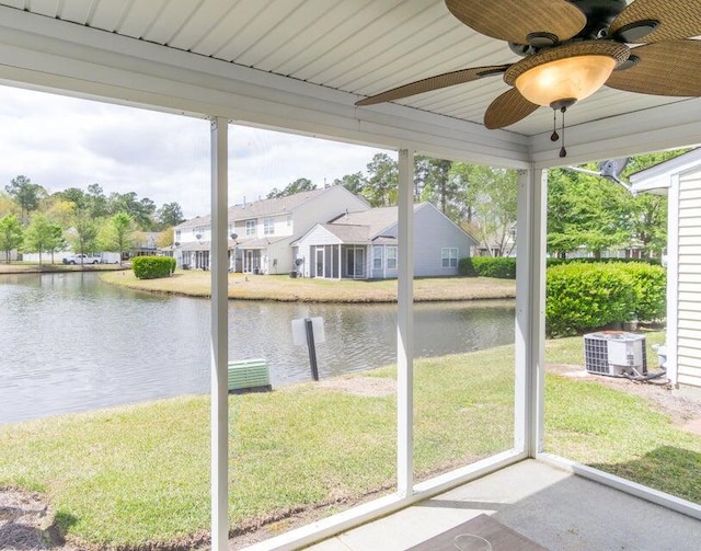 unfurnished sunroom featuring a wealth of natural light, a water view, and ceiling fan