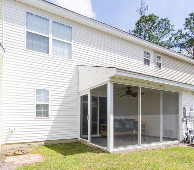 back of house featuring a yard, ceiling fan, and a sunroom