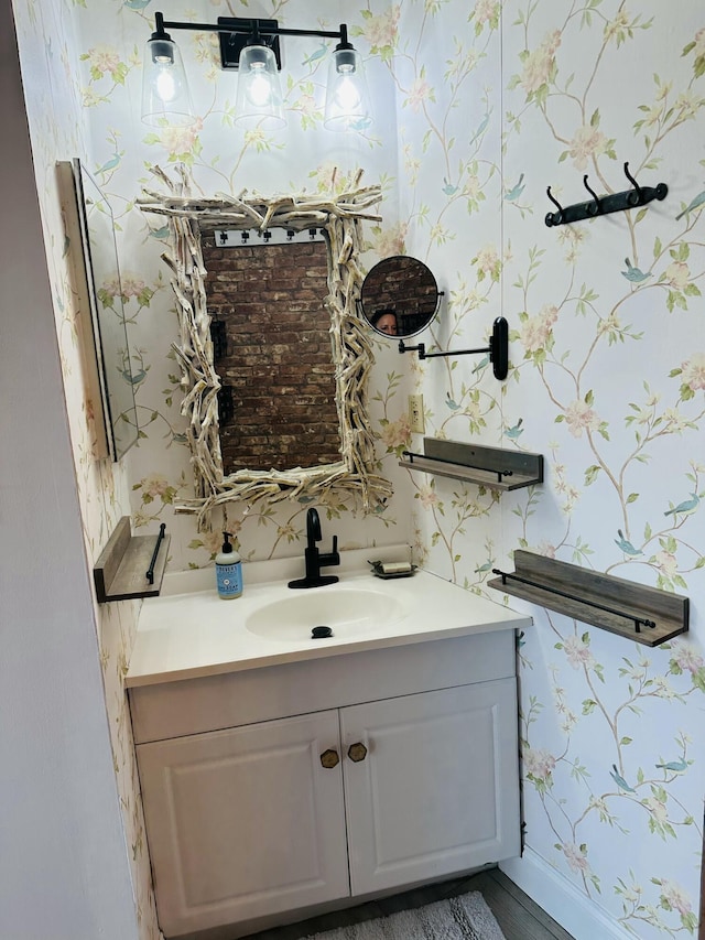 bathroom with wallpapered walls, vanity, and baseboards