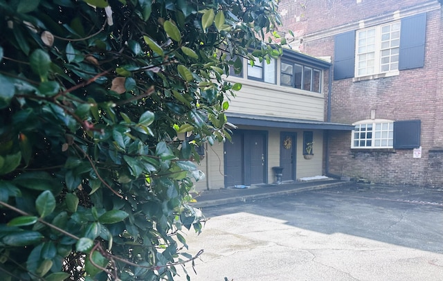 view of exterior entry with brick siding and covered porch