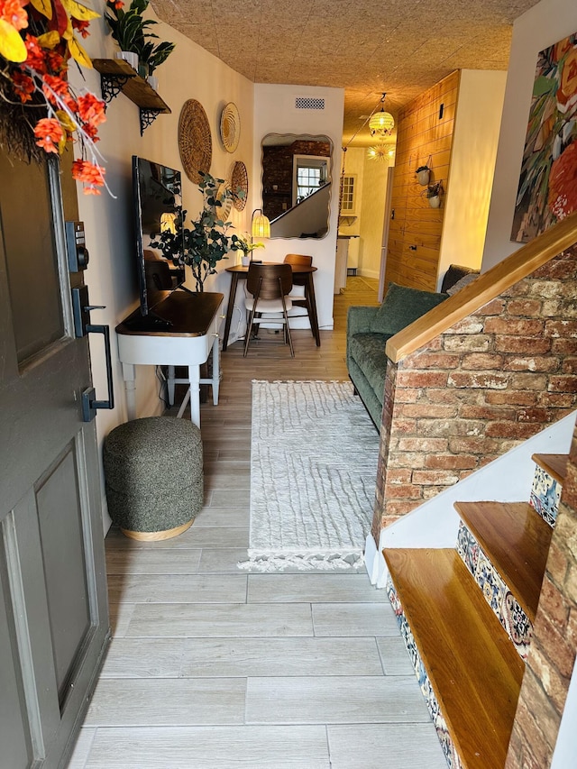 entryway featuring stairway, wood finished floors, and visible vents