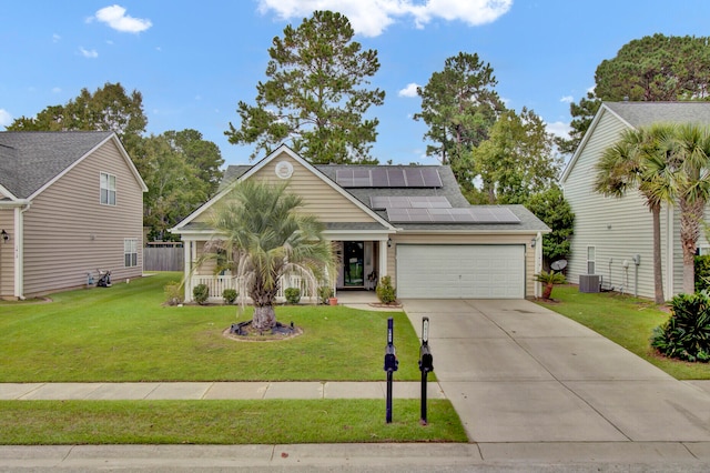 view of front of property featuring a garage, a front lawn, solar panels, and central AC unit