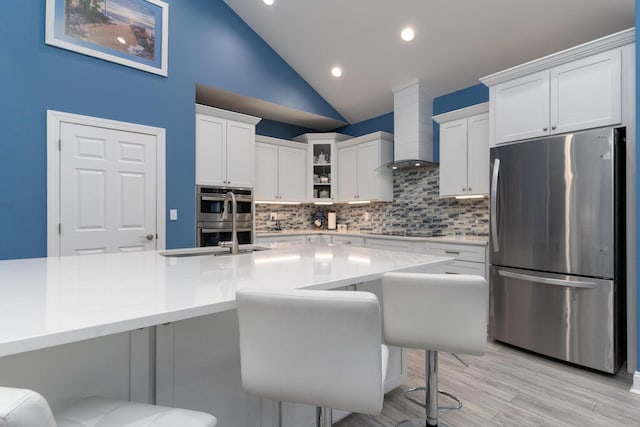 kitchen with light countertops, appliances with stainless steel finishes, tasteful backsplash, and wall chimney exhaust hood