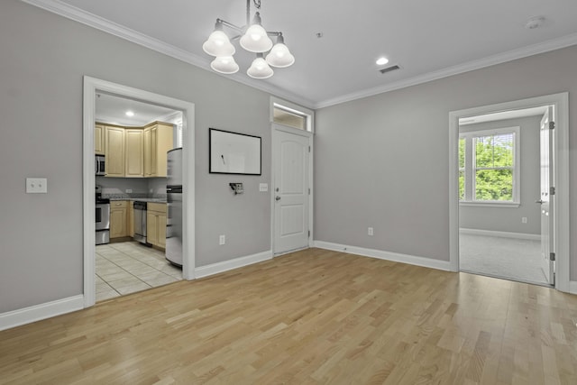 unfurnished dining area featuring light wood finished floors, visible vents, an inviting chandelier, and crown molding