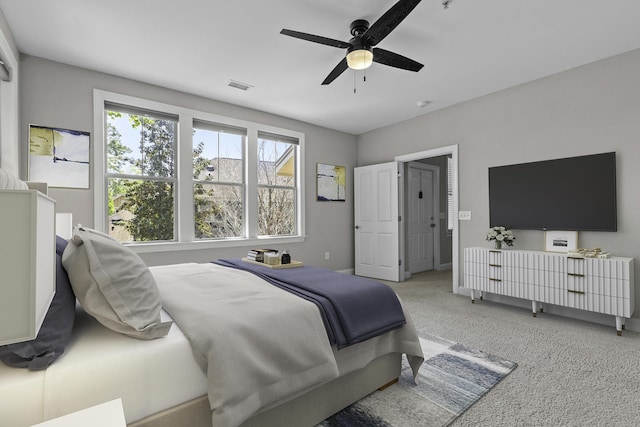 carpeted bedroom with ceiling fan, baseboards, and visible vents