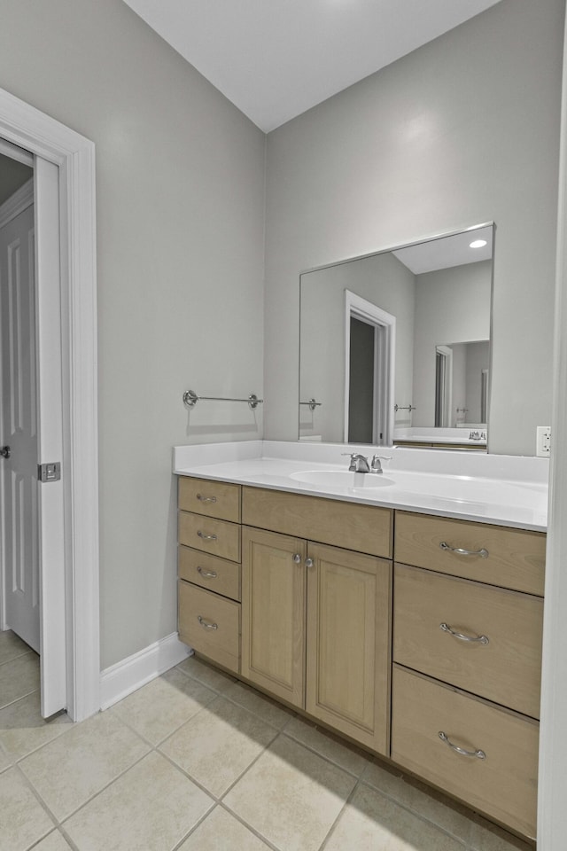 bathroom with baseboards, tile patterned flooring, and vanity