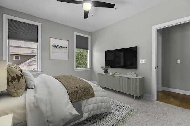 bedroom featuring ceiling fan, light carpet, and baseboards