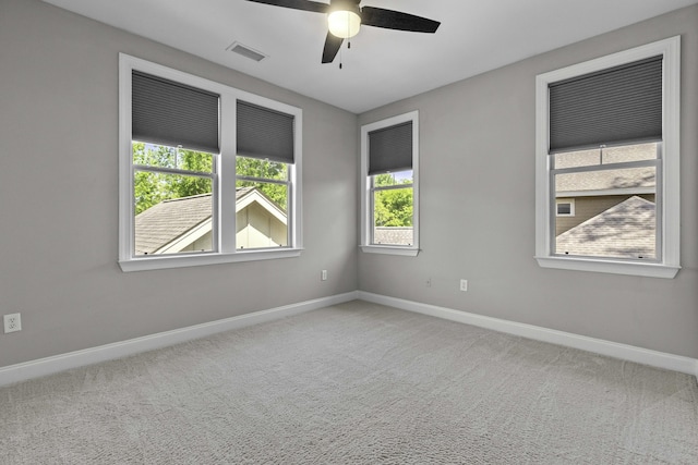 empty room with baseboards, a ceiling fan, visible vents, and carpet