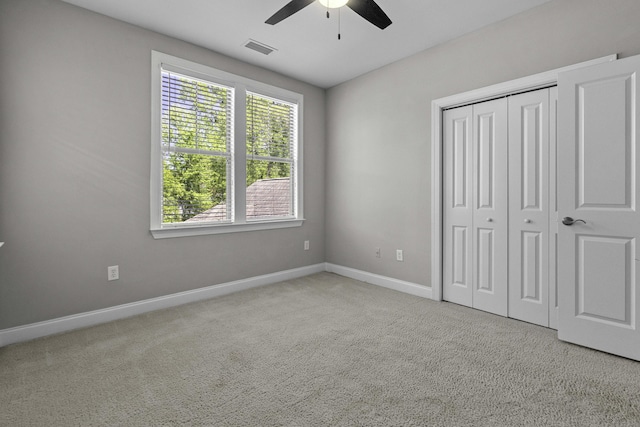 unfurnished bedroom with a ceiling fan, a closet, carpet, baseboards, and visible vents
