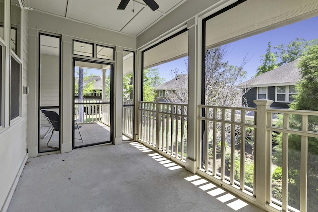 unfurnished sunroom with ceiling fan