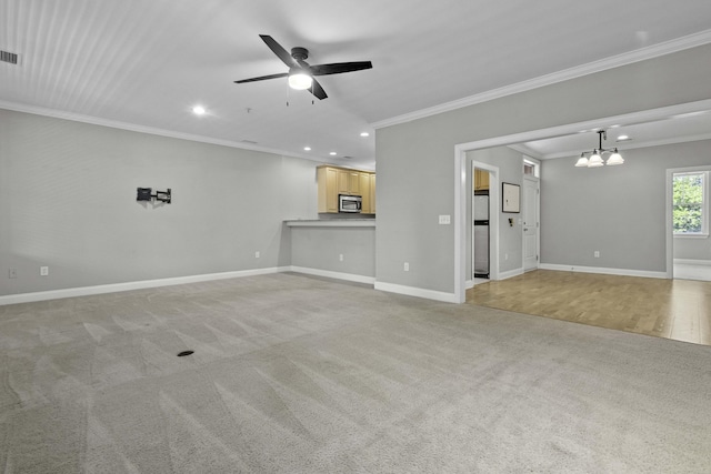 unfurnished living room with light carpet, baseboards, recessed lighting, ceiling fan with notable chandelier, and ornamental molding